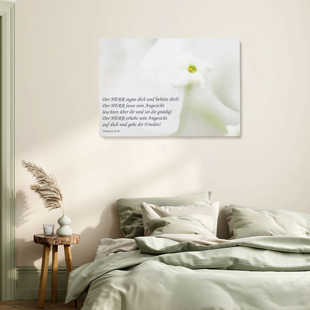 Mockup eines christlichen Wandbildes mit heller Blüte und dem Segen aus 4. Mose 6,24–26 über einem Bett im Schlafzimmer