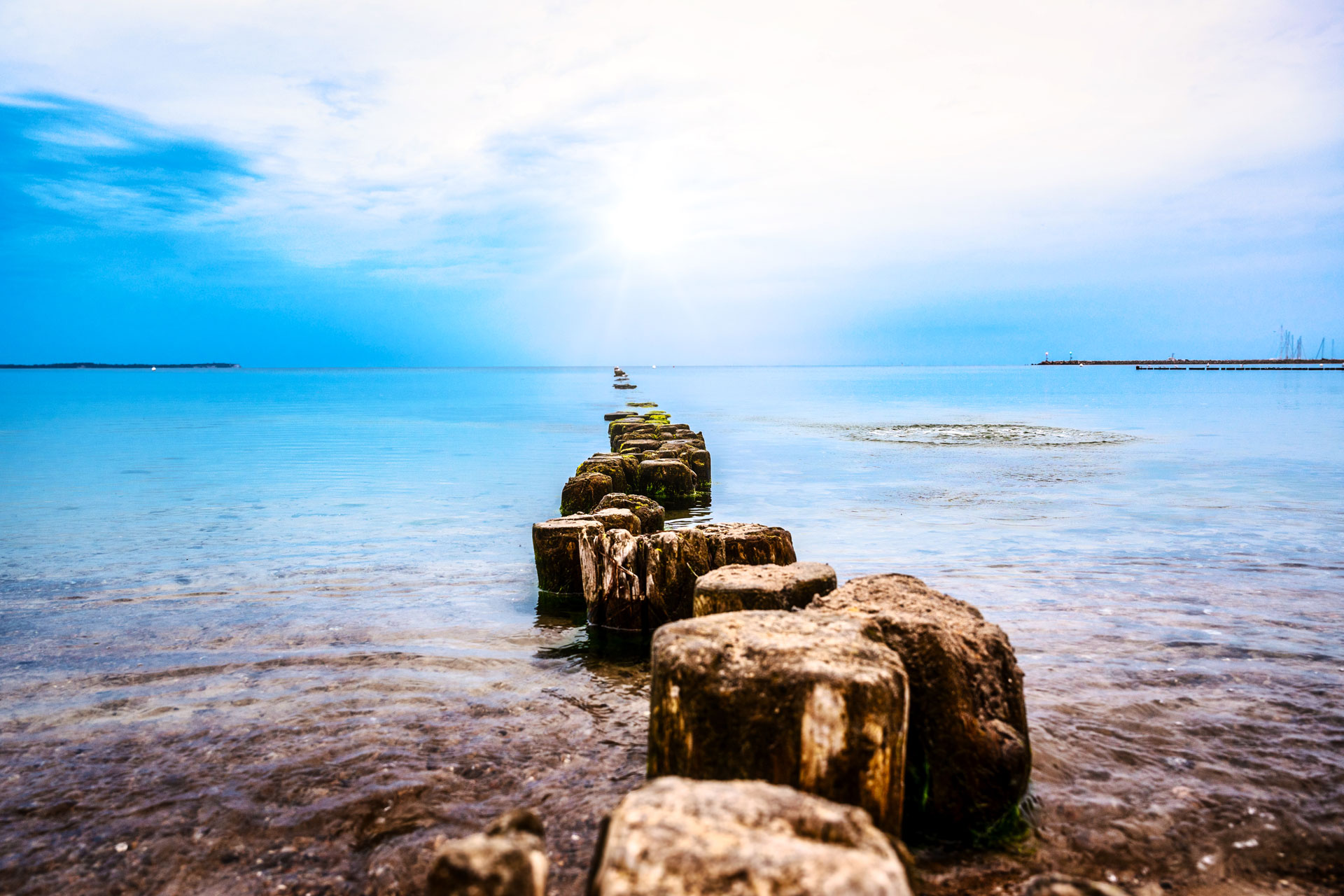 Holzbuhnen am Strand auf Rügen Alte Holzbuhnen am ruhigen Strand auf Rügen, die bei stillem Meer ins Wasser führen