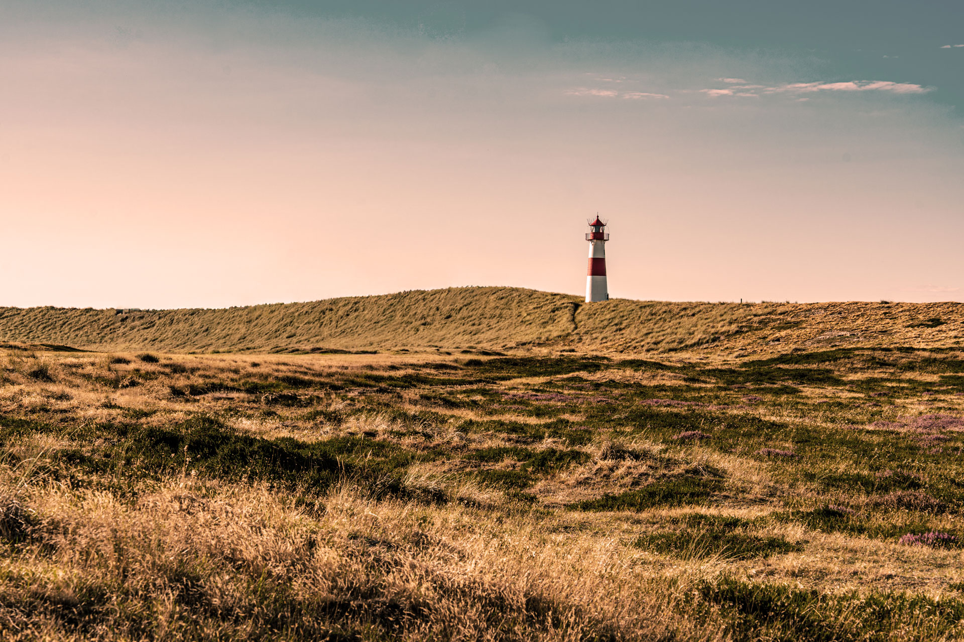 Leuchtturm auf Sylt in Dünenlandschaft – Sepia Leuchtturm auf Sylt in weiter Dünenlandschaft unter warmem Himmel im Sepia-Look
